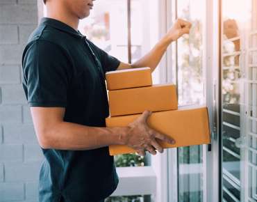 Delivery agent handing over packages at front door